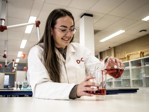 Lachende lab student met glazen bekers